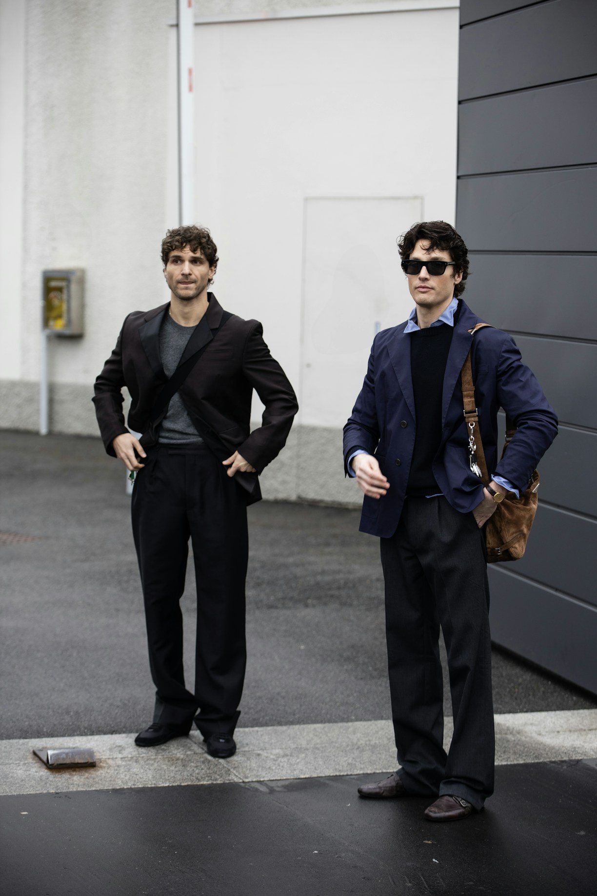 Two men standing next to each other in front of a building