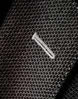 Close-up of a finely stitched lapel on a charcoal gray suit jacket.